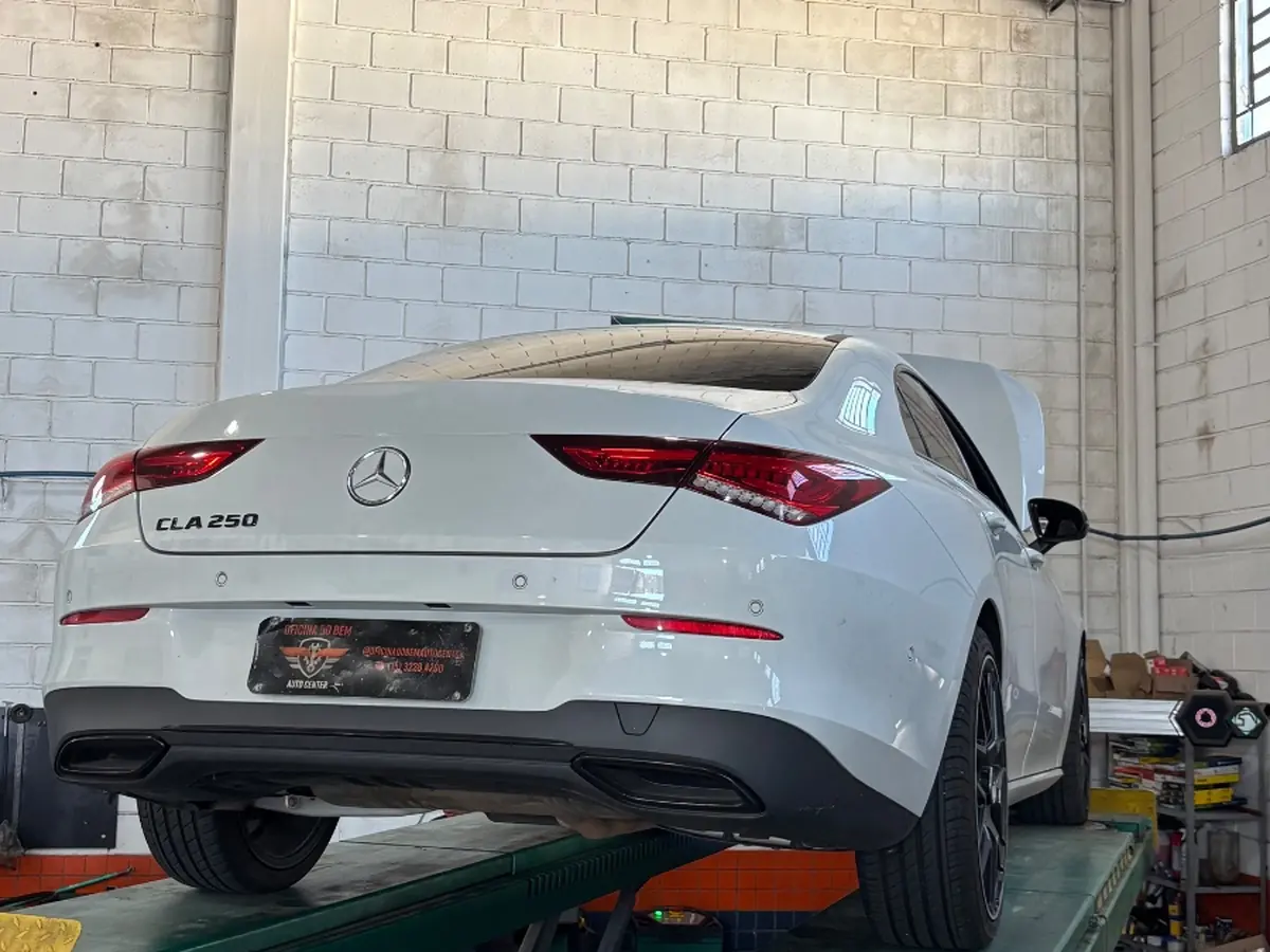 Mercedes-Benz CLA 250 branco no elevador da Oficina do Bem, com capô aberto